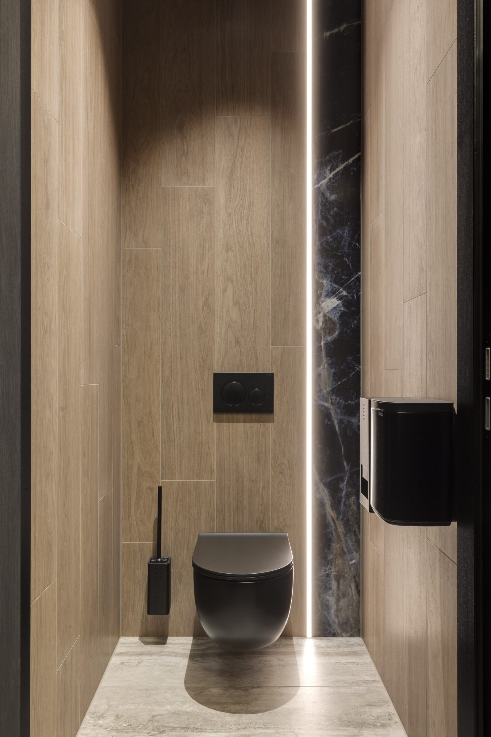 Wc-hok in Studio Daphne Jansen met zwarte wc, zwarte wc-spoelknop en zwarte wc-borstelhouder, houten en stenen muur