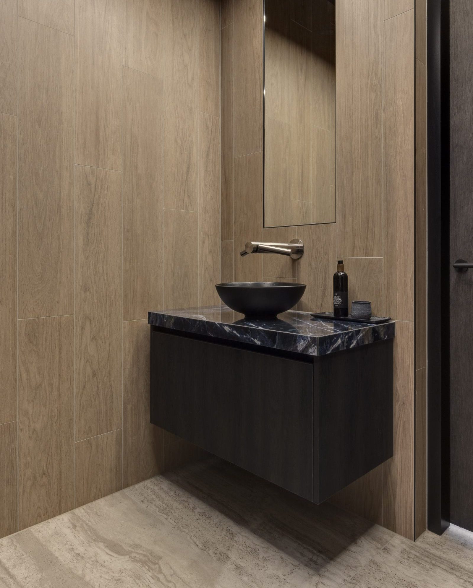 Wastafel in Studio Daphne Jansen met zwarte wc, zwarte wctafel, gouden kraan en houten muren